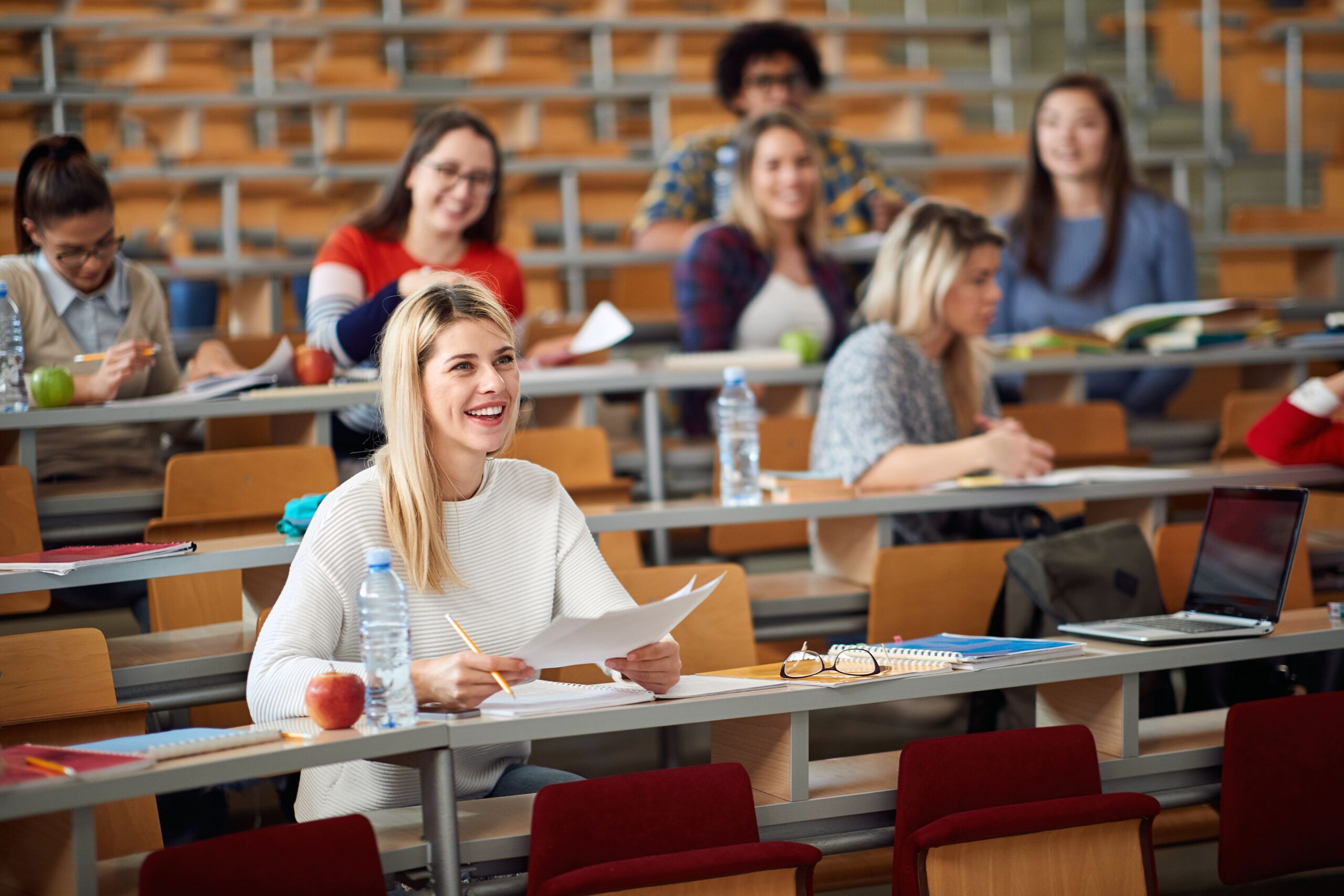 Frau sitzt mit Komilitonen im Hörsaal ©AdobeStock