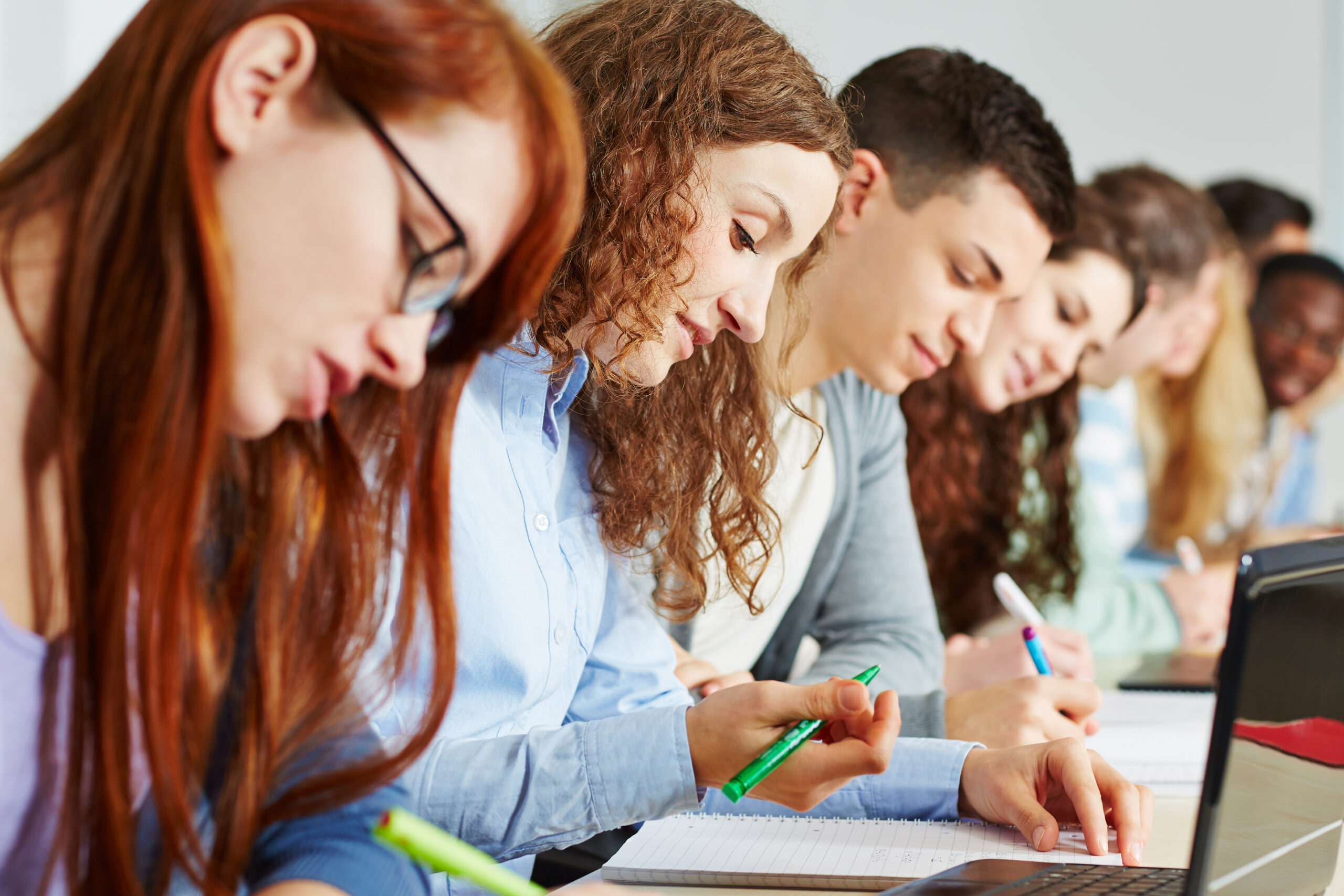 Dual Studierende sitzen in der Hochschule und lernen.